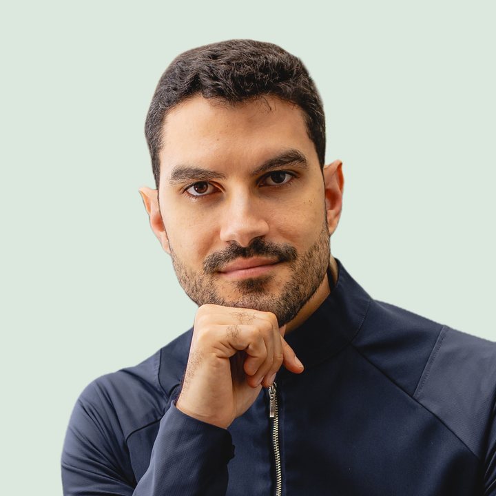 Thiago Sampaio, nutricionista, com a mão no queixo, olhando pra câmera